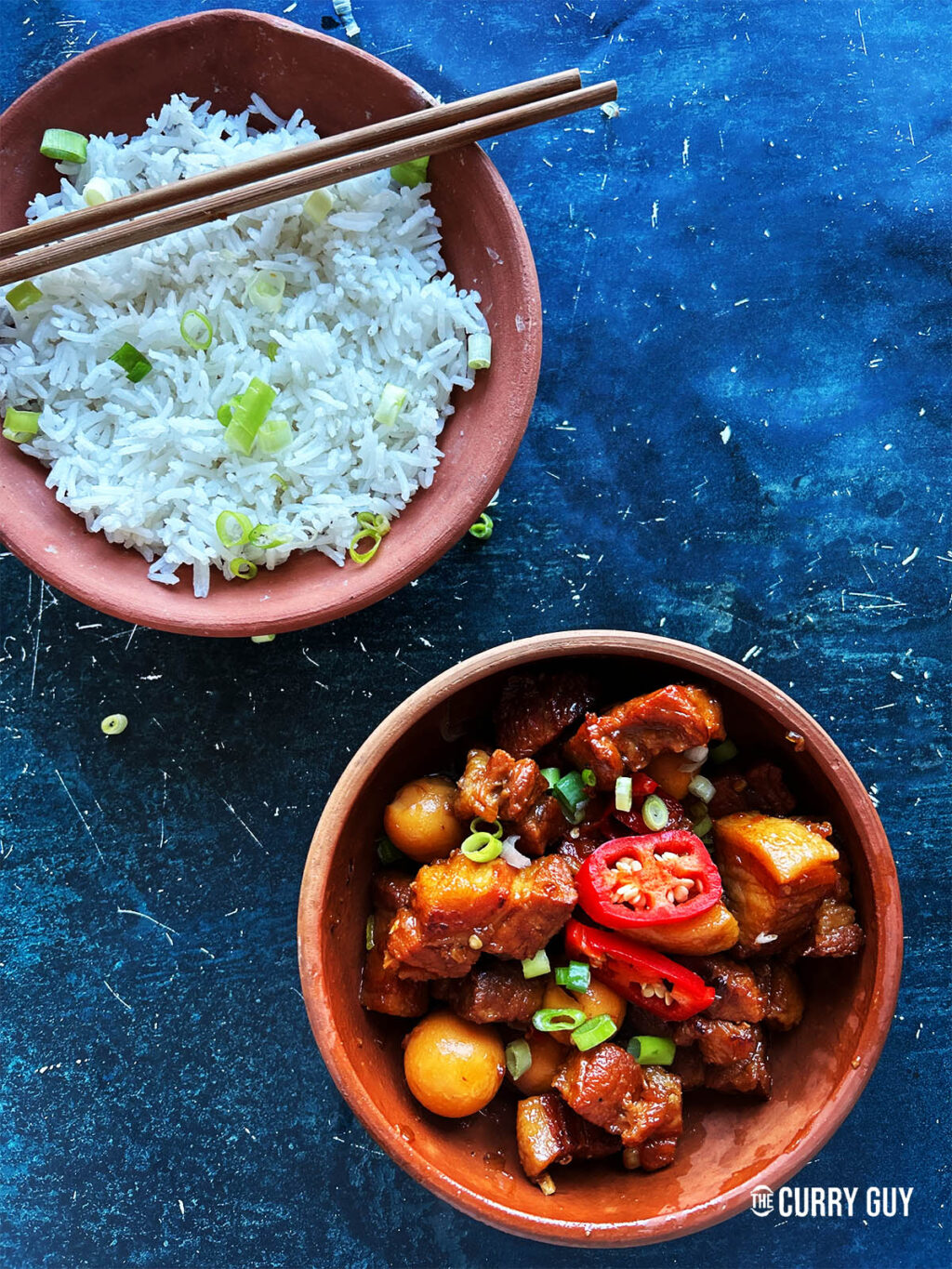 Thit Kho tao in a serving bowl next to a bowl of rice.